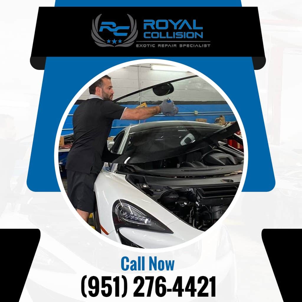 Auto glass technicians using suction cups to carefully install a new front windshield onto a white McLaren sports car in a repair shop.