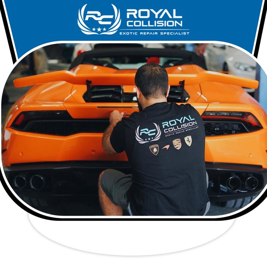 A Royal Collision specialist aligning and securing the rear wing spoiler on an orange Lamborghini supercar inside the repair facility.
